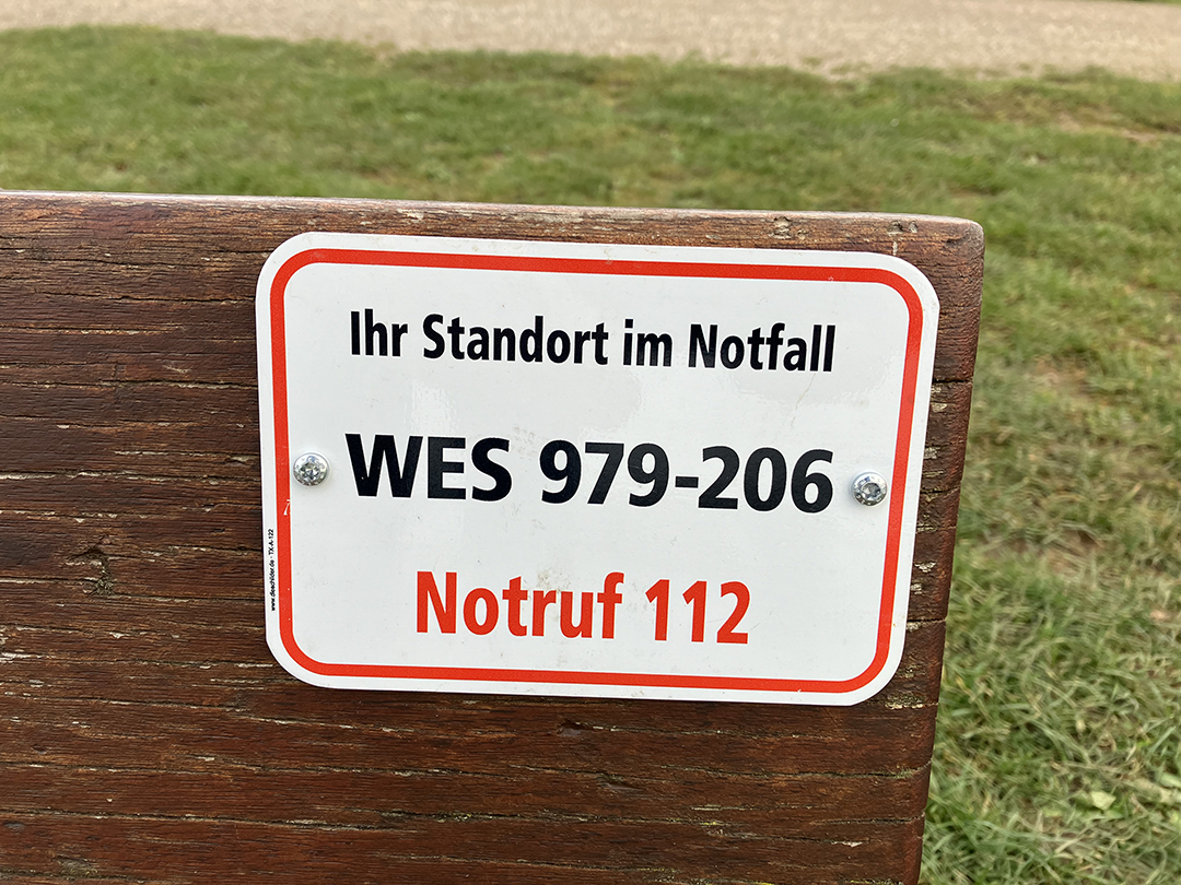 Ein Schild an einer Sitzbank auf der eine Identifikationsnummer steht