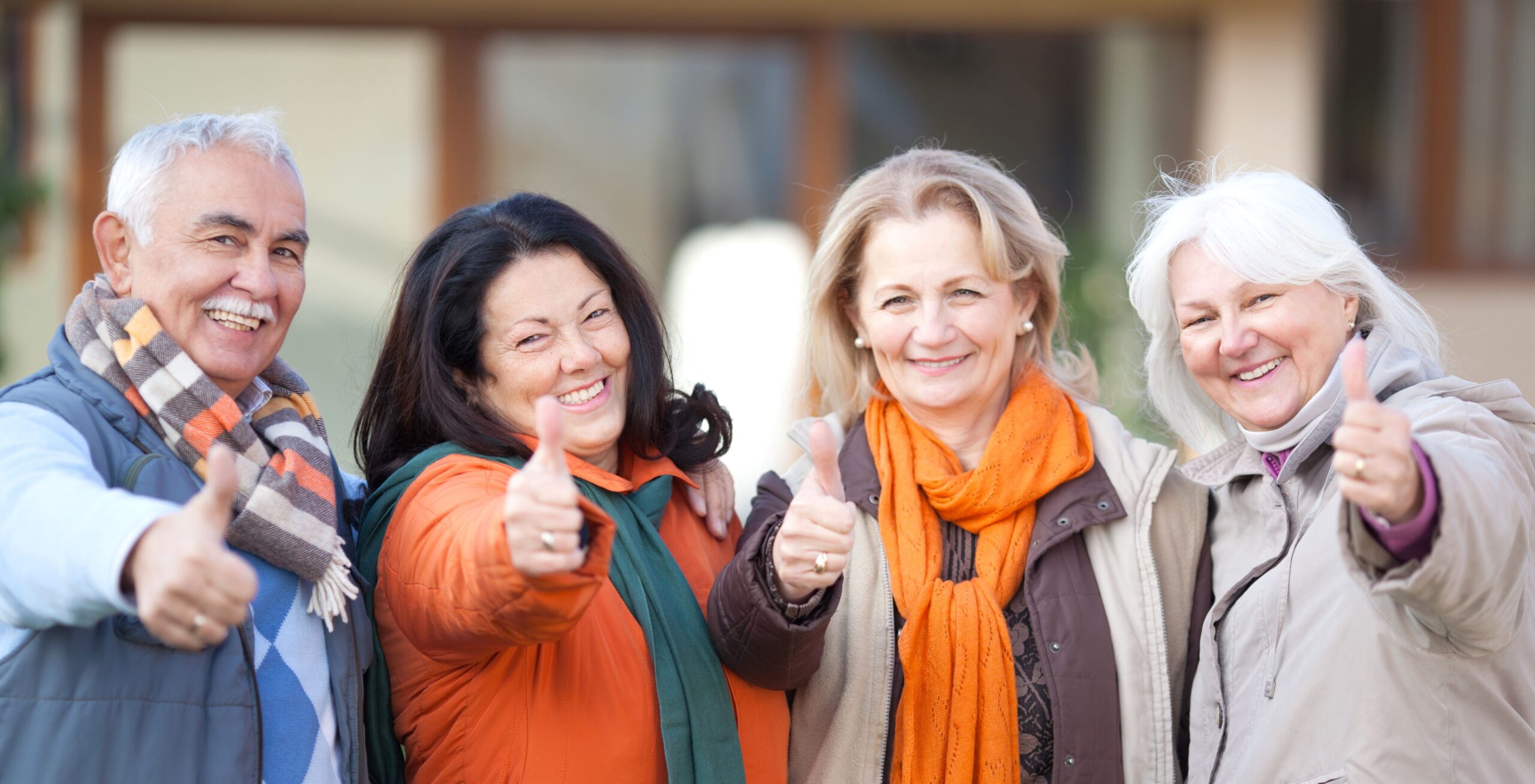 Vier Senior*innen halten den Daumen hoch